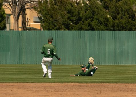 Ryan Duncan, USAOs center fielder, makes a diving catch and manages to keep the ball in his glove while teammate, Nick Fleckenstein watches.