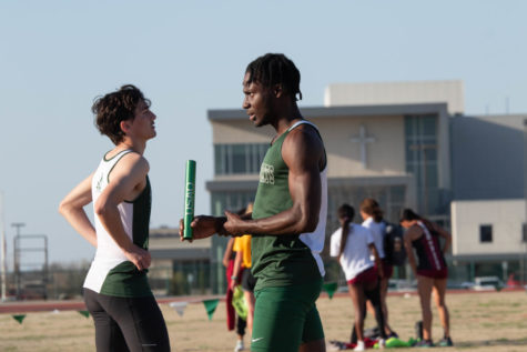 Quintin Pennells and Kemoy Willis discuss their event at an outdoor track and field meet. 
