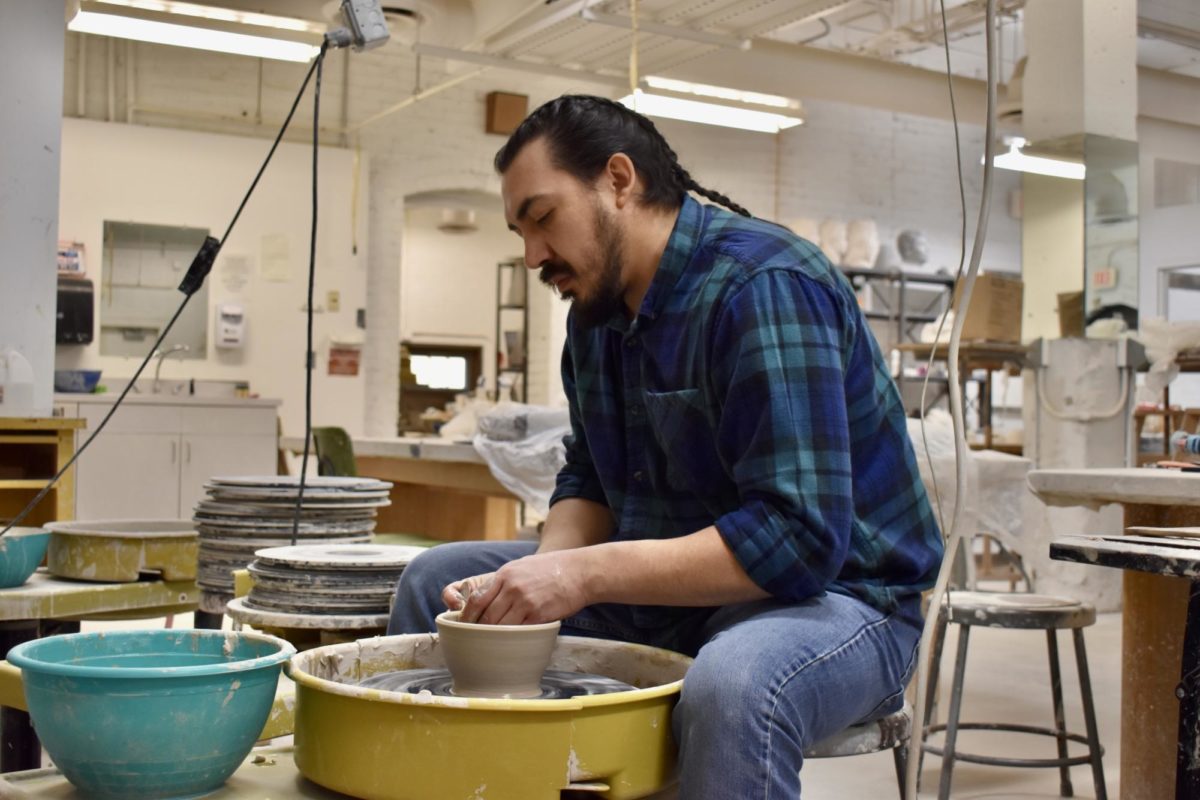 Freddy Baeza works in USAOs Art Annex on a ceramic bowl. After molding the clay into the desired shape, Baeza used a unqiue technique to make the bowl a one-of-a-kind item.