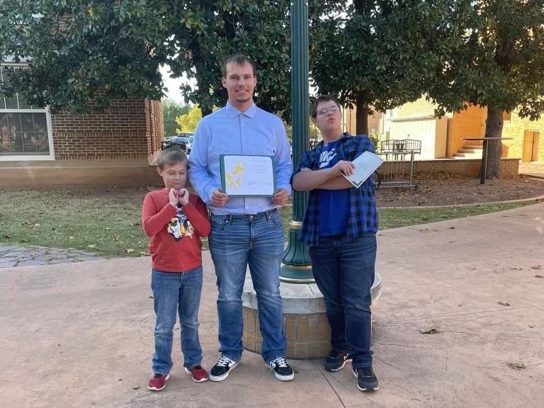 Gary Jackson (center) stands with his two younger brothesrs, Adam (left) and Vincent Murphy (right), after winning an award at the annual Minera Awards ceremony.