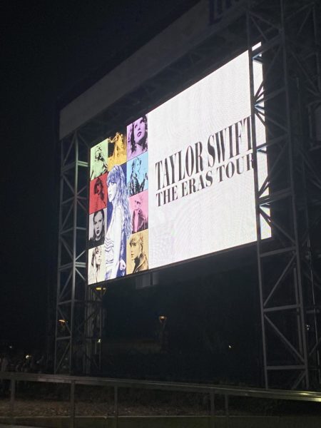 A large screen illuminates the stadium and showcases all of Taylor Swifts album covers for her Eras Tour. 