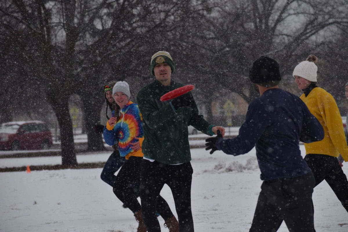 Thomas Wilcock, adjunct instructor, tosses the disc to Chris Albrecht, a Chickasha educator, in a snowy game earlier in 2023.