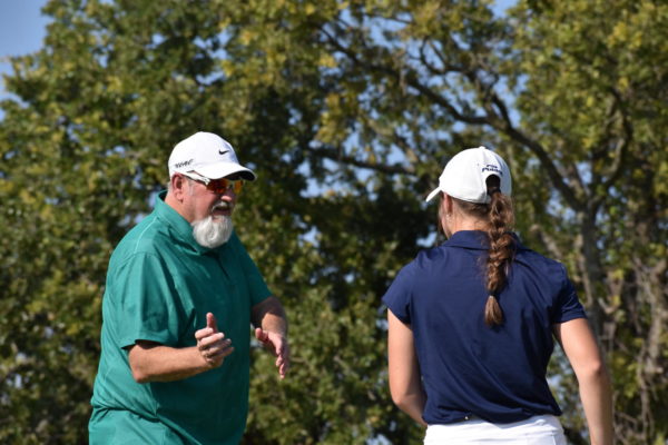 Coach Steve Holden gives Hudson Woloss advice before she steps up to take her next shot.