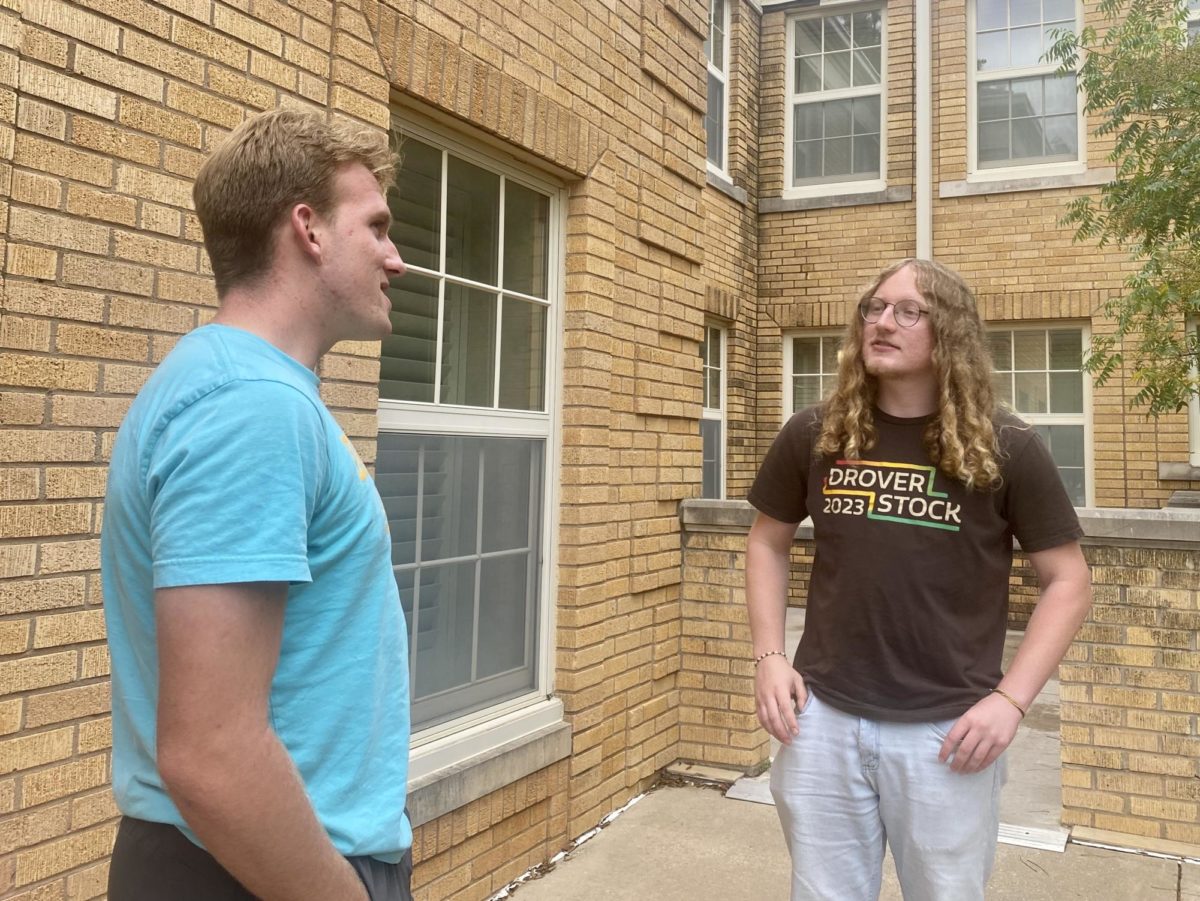Skyler Sturgis-Garneau, a housing coordinator, speaks with Harry Cracknell, a resident assistant, outside of the Lawson Clubhouse. 