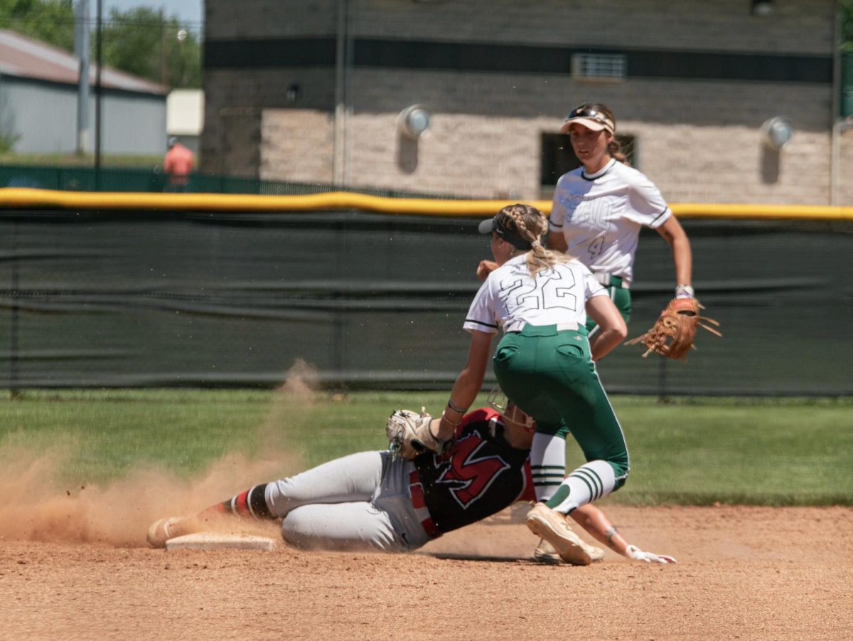 In a game last season, Malea McMurtrey throws her glove down in an attempt to tag out a MACU runner, while teammate Sierra Selfridge backs up the play.
