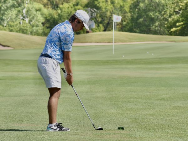 Sophomore Conner Cryer prepares to chip his ball onto the green at the teams home course.