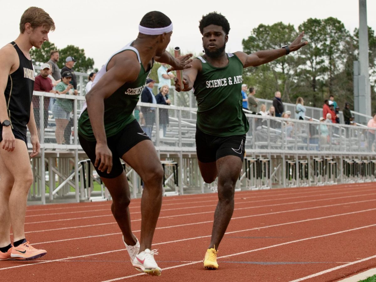 Crispin Mbii and Tyrike Cunningham compete in the relay portion of the meet in Arkansas.