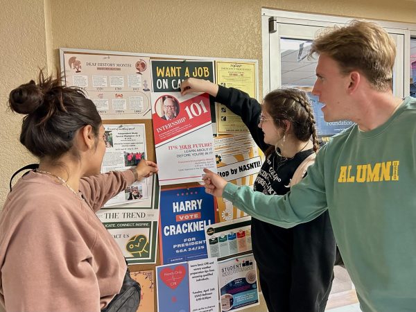 Students, including Gisela Alonso, Mary-Grace McNutt, and Harry Cracknell, in the PR class were tasked with hanging posters for Internship 101 around campus.