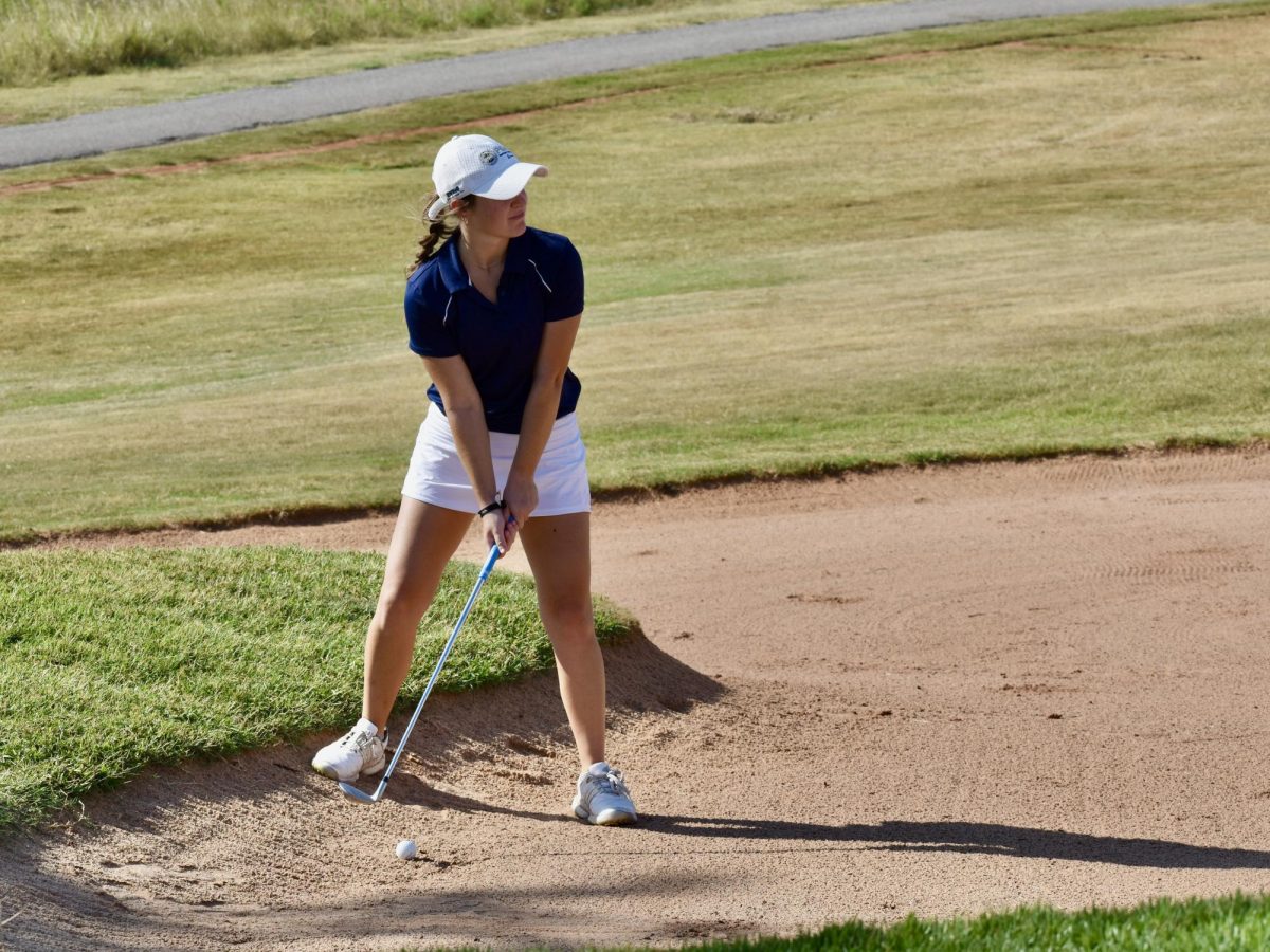 Hudson Woloss looks to hit her ball out of a bunker at Winter Creek Golf Course during a practice round. 