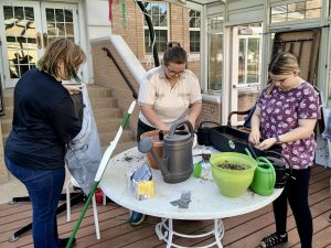 Sierra Whittaker and other Garden Club members work to make the greenhouse space a better place for their plants. 