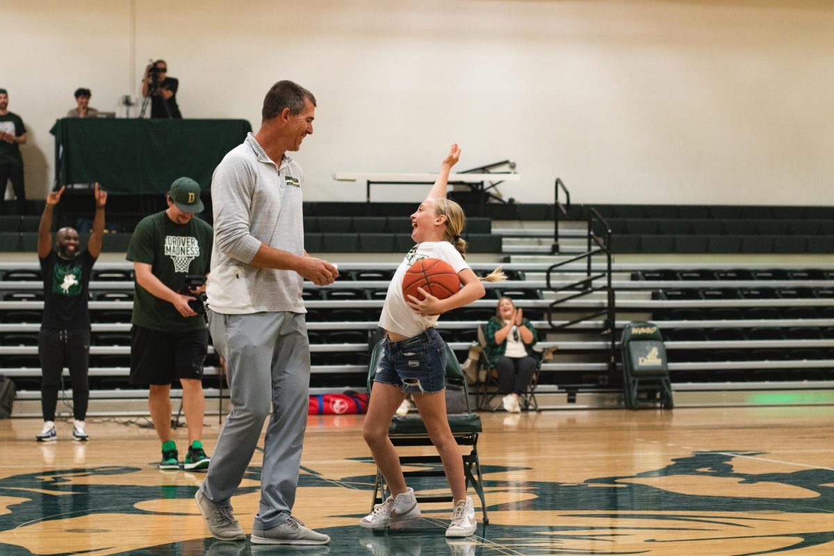 Athletic Director Mike Ross high fives the young girl who won musical chairs.