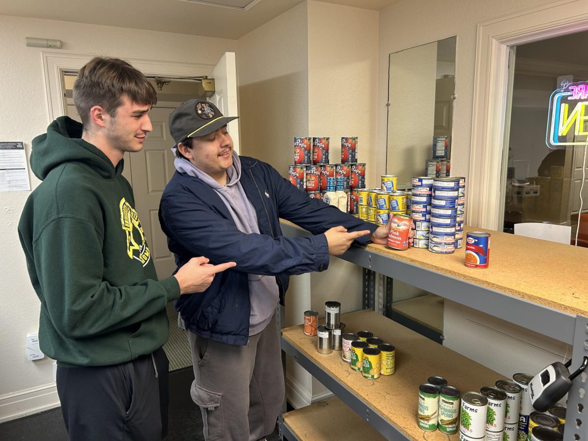 Colby Keller (left) and AJ Jackson (right) check out the canned goods in the food pantry. 