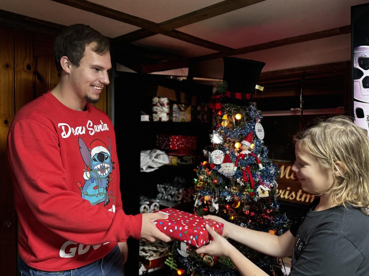 Editor-in-Chief Gary Jackson hands a present to his younger brother Adam Murphy. 