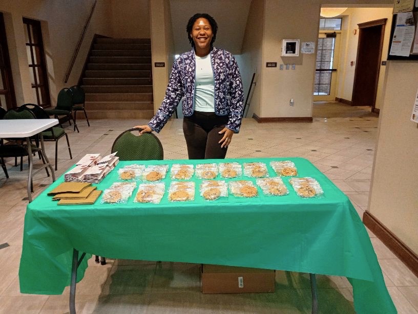 Trinity Chatman, SGA's Health and Wellness Committee chair, hands out cookies and pamphlets out the cafeteria on Monday, Feb. 10.