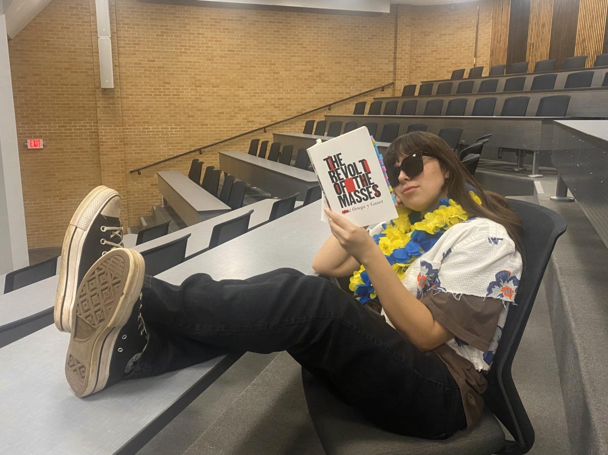 Hayla Wilson holds up the book "The Revolt of the Masses" by Jorge Ortega Y Gaset. Her independent study explored the book and it's views on mass culture influencing civilizations. 