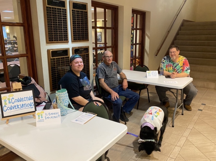 Connecting Conversations members Indigo Jude (left) with dog Bean, Jack Donnellan, and John Moroney (right) await conversations from willing participants. 
